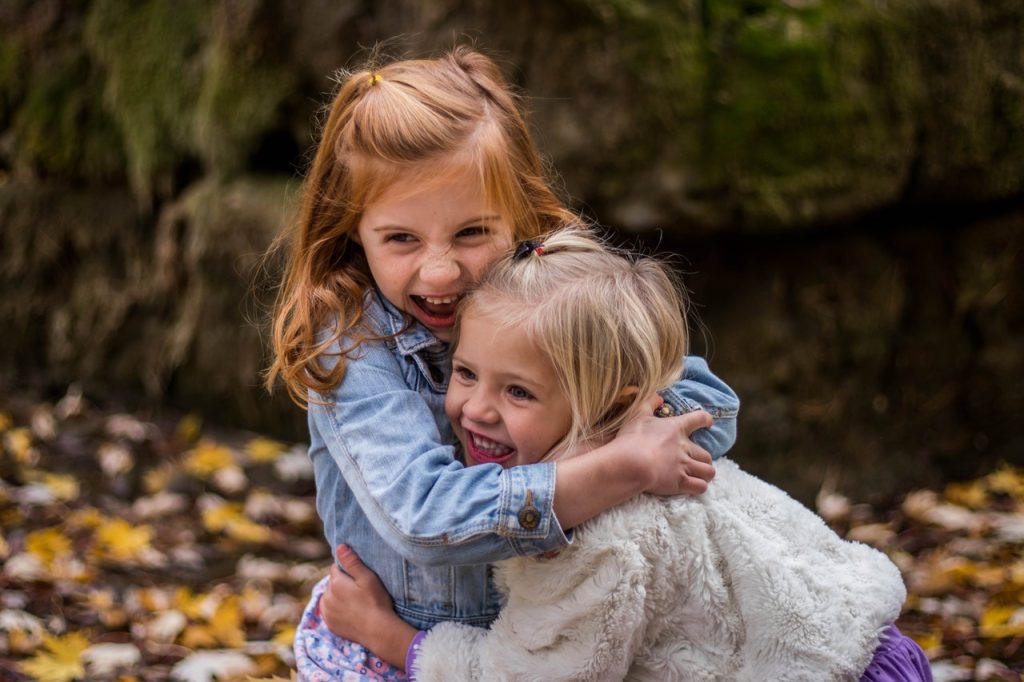 2-girls-hugging-each-other-outdoor-during-daytime-225017