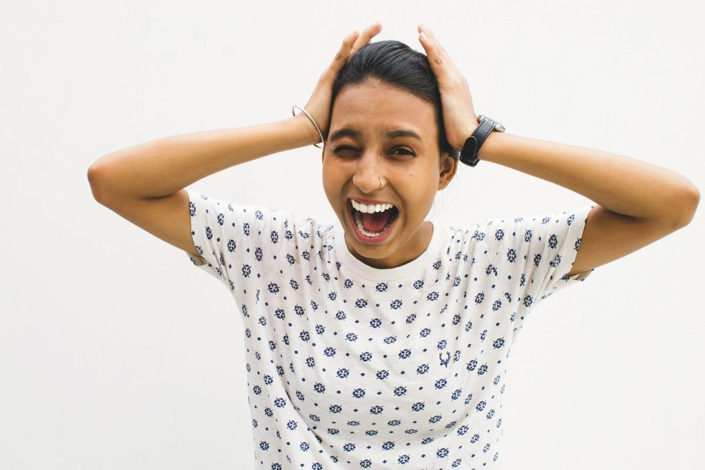 Woman screaming with her hands on her head as she searched for how to manage anxiety