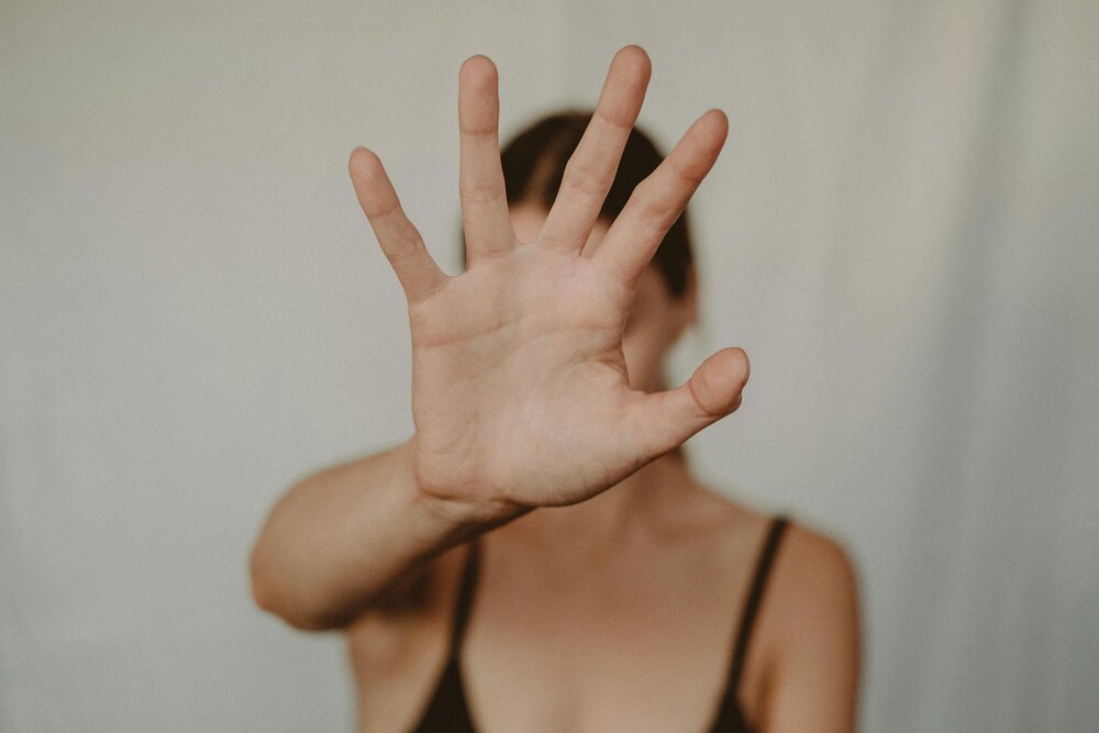 Woman with her hand in the air demonstrating how to set boundaries with family members