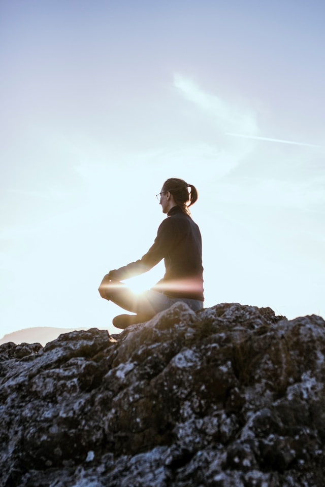 woman sitting calmly on a rock