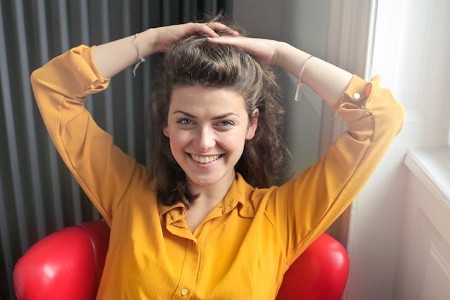 Woman with hands on her head relaxed and smiling